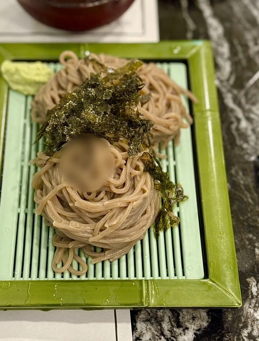 Soba broth with floating ice chips and noodles