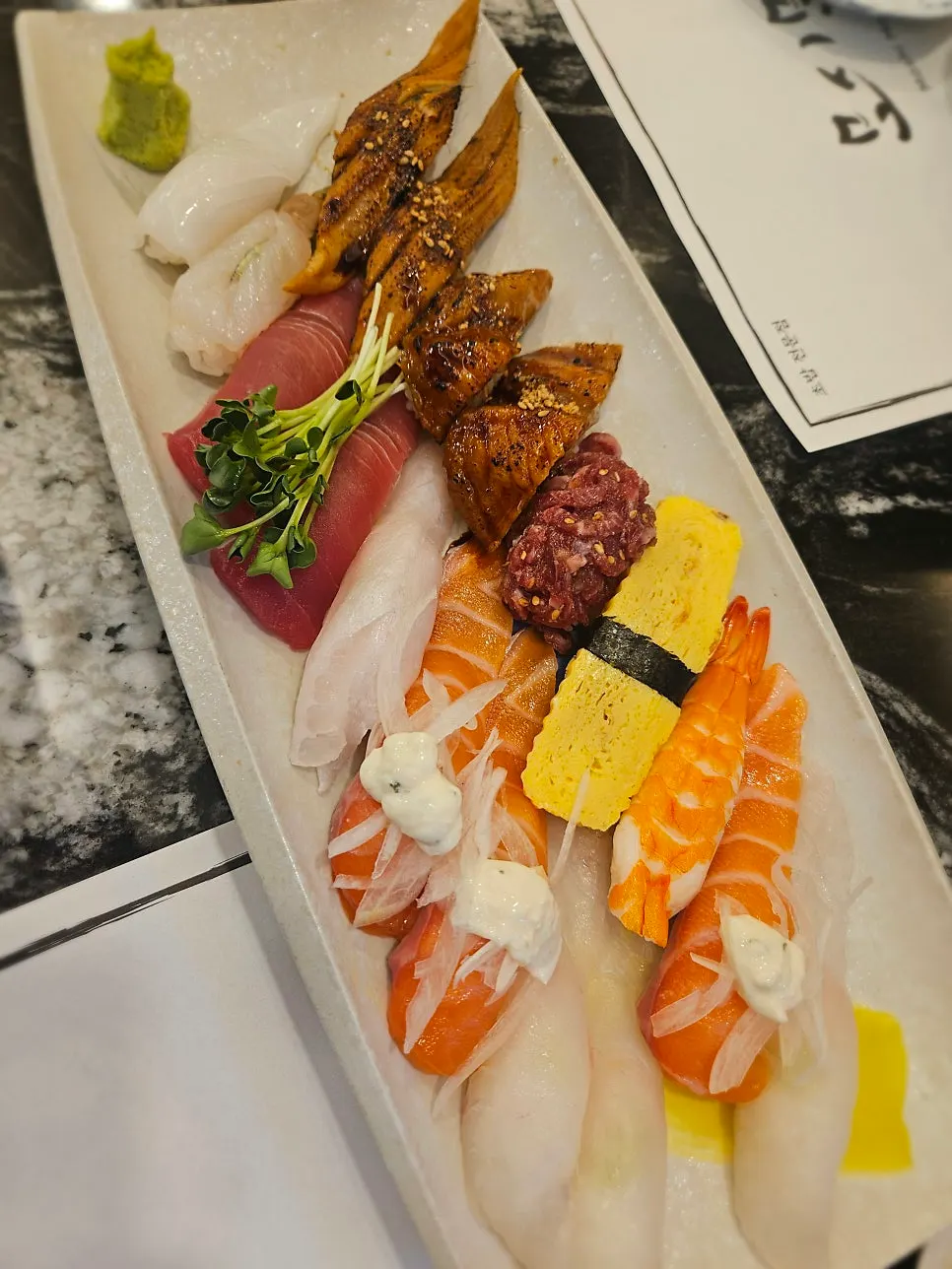 Sushi assortment including eel, salmon, and tuna