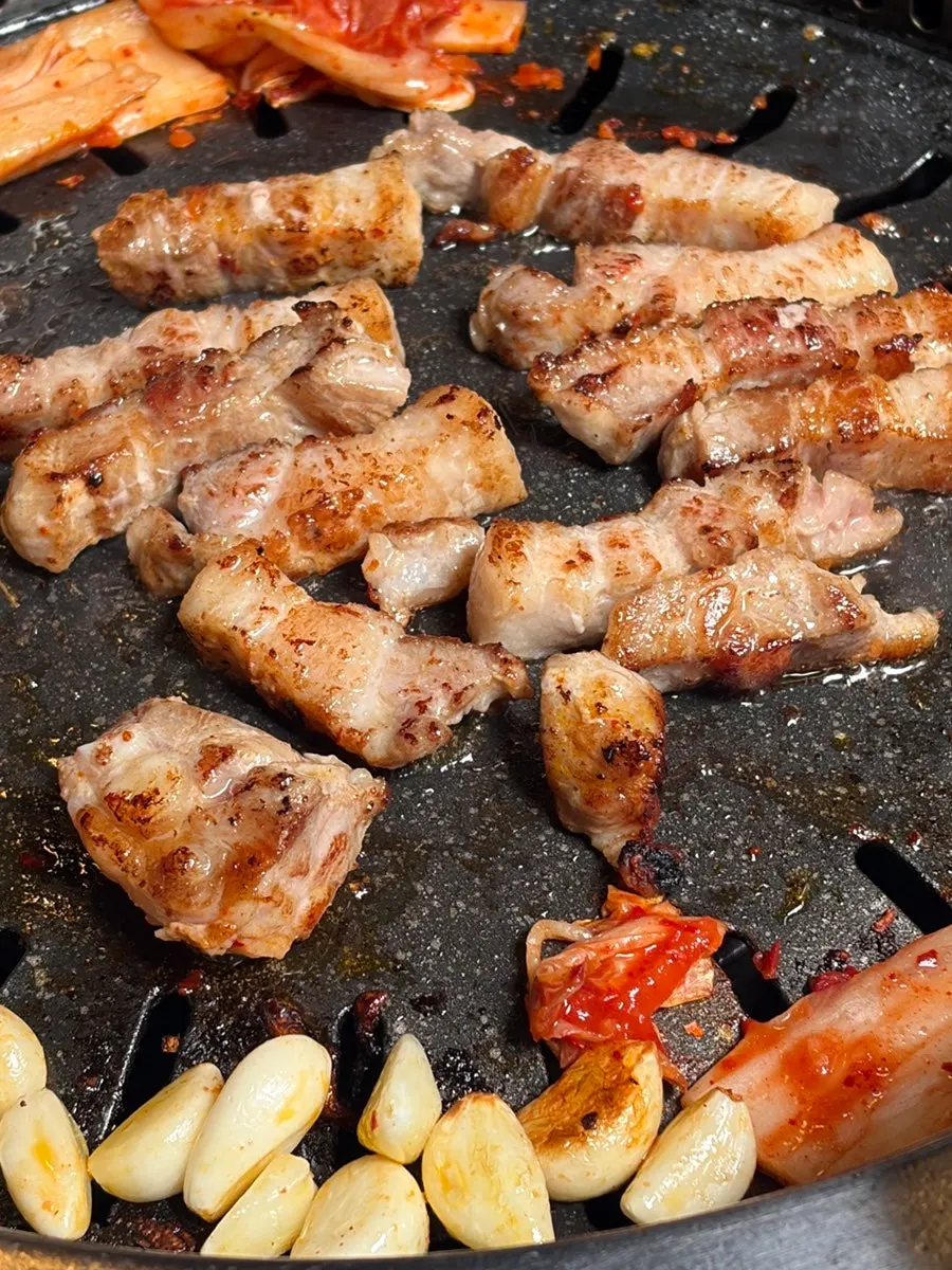 Kimchi and whole garlic grilled together on the pan