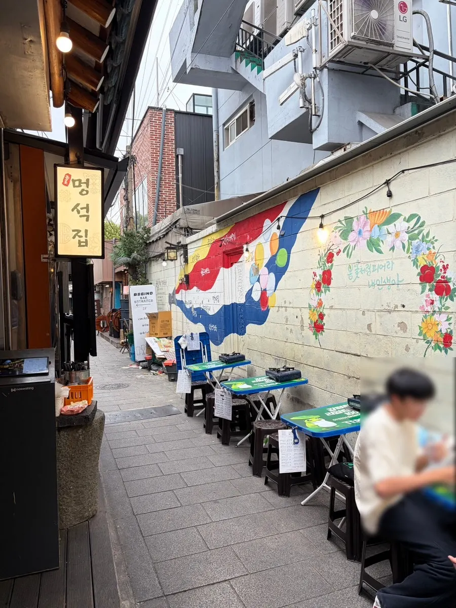 Outdoor seating placed in the Ikseon-dong alley in front of Meongseokjip