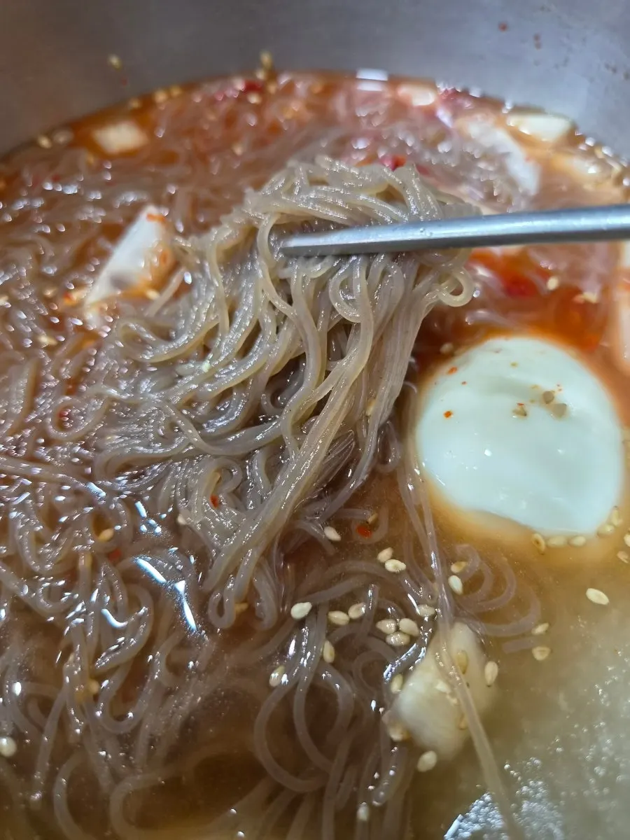 Naengmyeon eaten alongside seasoned ribs