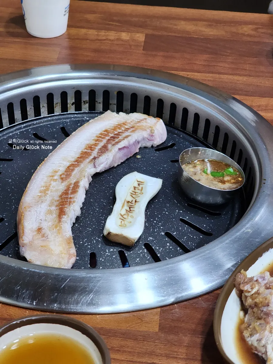 Black pork belly grilling alongside myeoljeot
