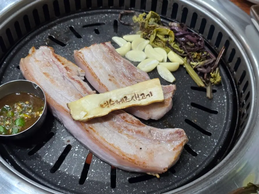 Pork belly with garlic, mushrooms, and bracken on the grill