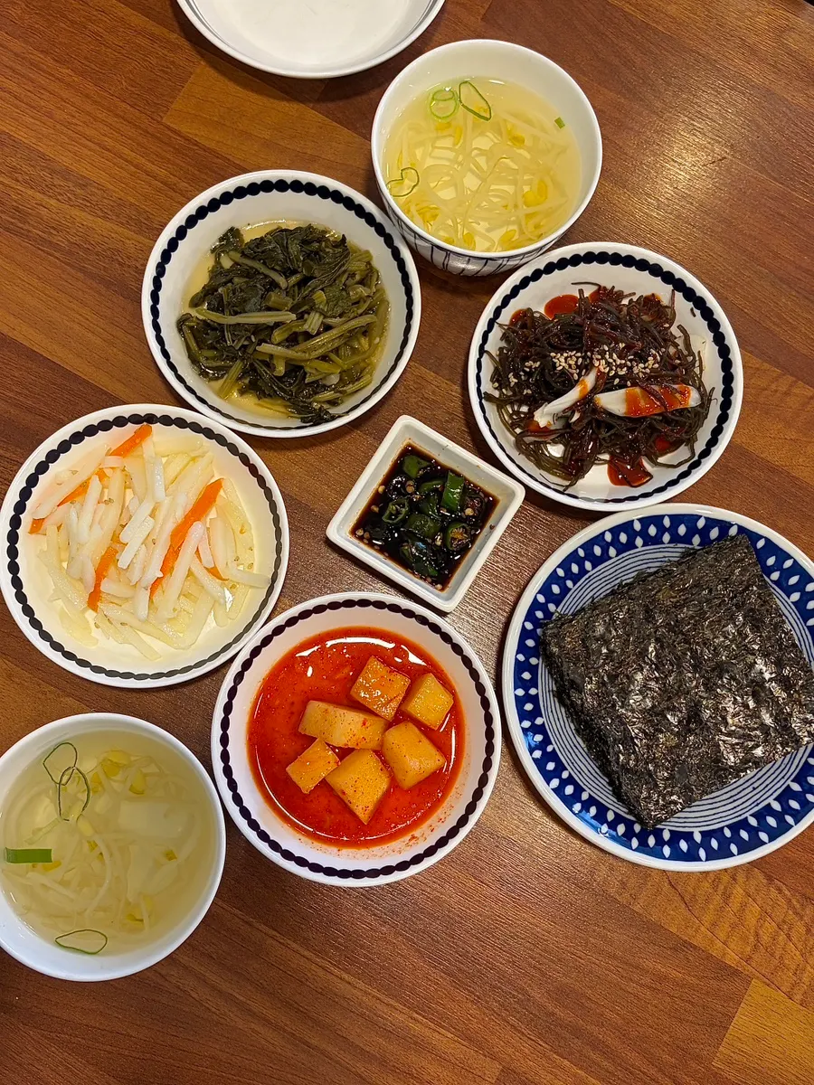 Table setting with small spicy braised pollock and rice bowls