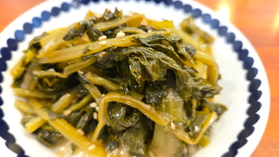 A side dish plate served alongside the braised pollock