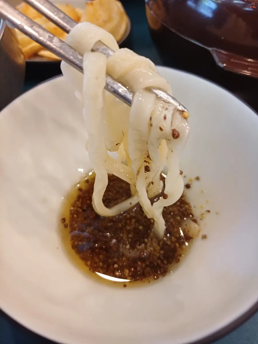 들기름장에 버무린 칼국수 면과 닭고기