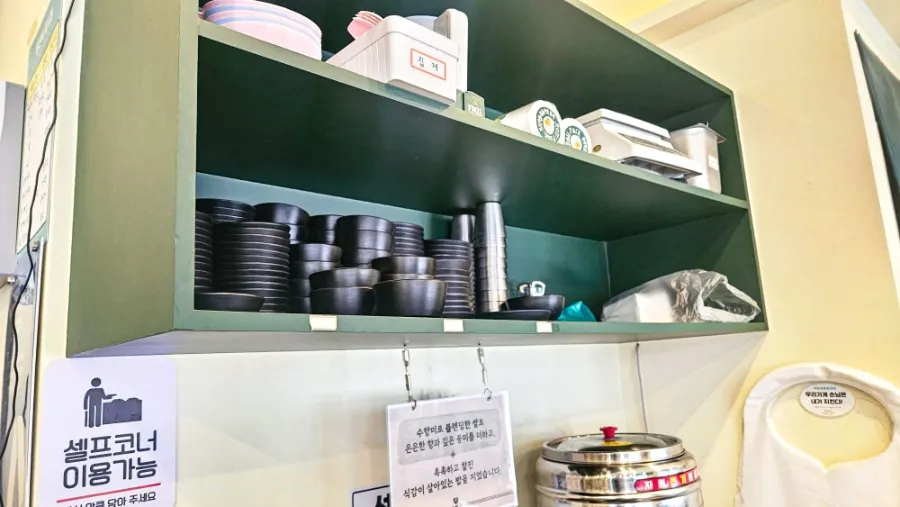 Self-serve bar with broth, rice, bowls and aprons