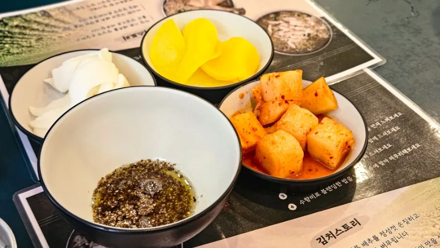 Table with self-serve banchan and sesame oil sauce
