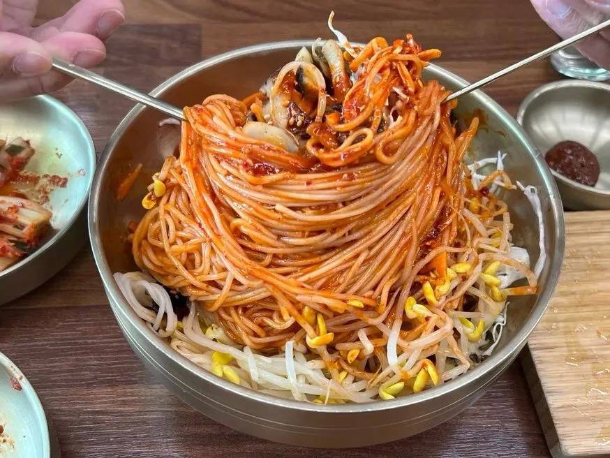 소라와 채소 토핑이 가득한 비빔국수