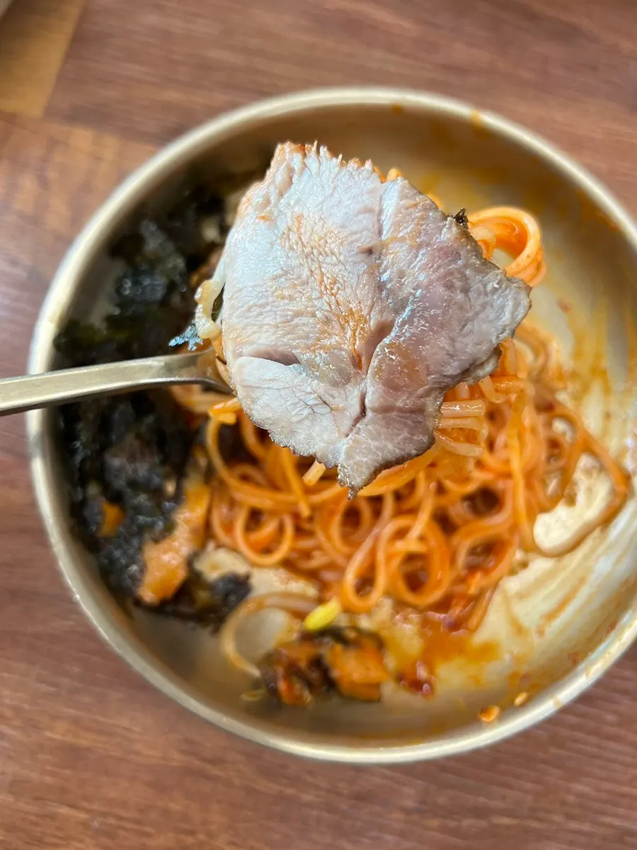 비빔국수 위에 돔베고기를 올린 한입