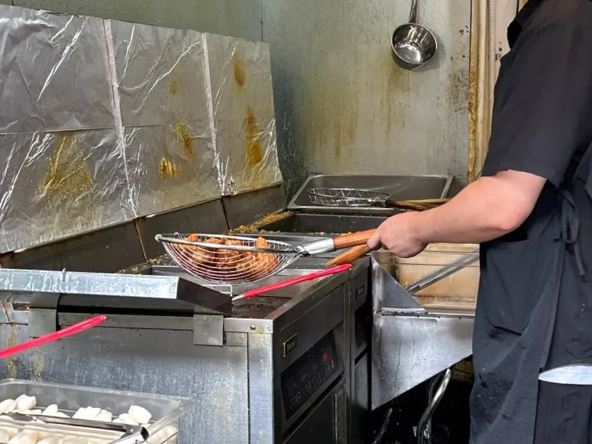 Freshly fried dakgangjeong being tossed in sauce