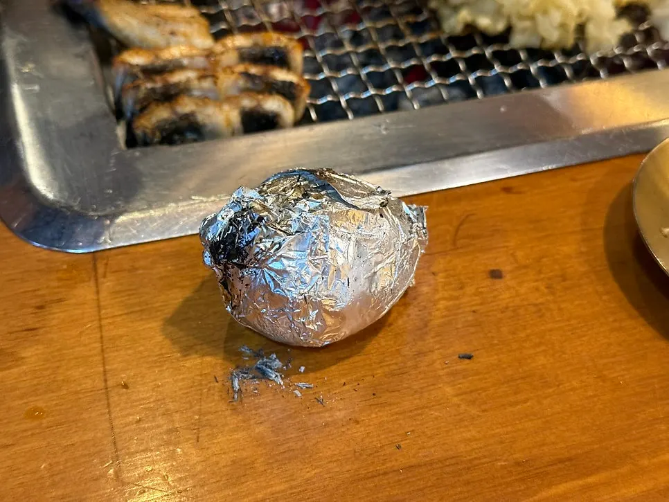 Foil-wrapped charcoal-grilled potato