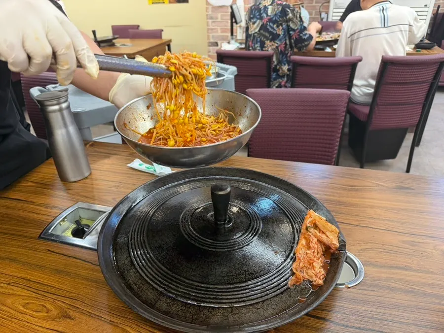 Bean sprouts and kimchi placed on top of the sotddukkeong griddle