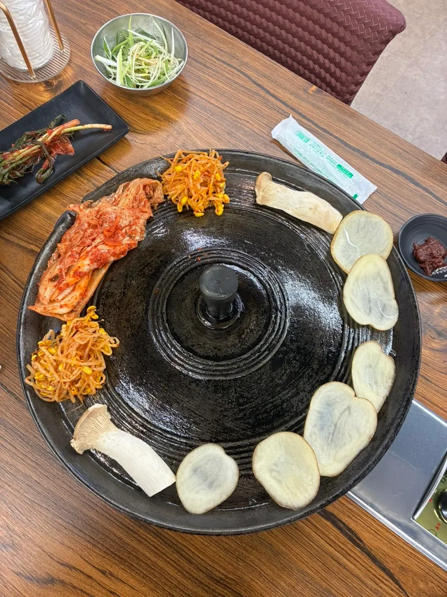 Meat and grilled cheese on the cauldron lid