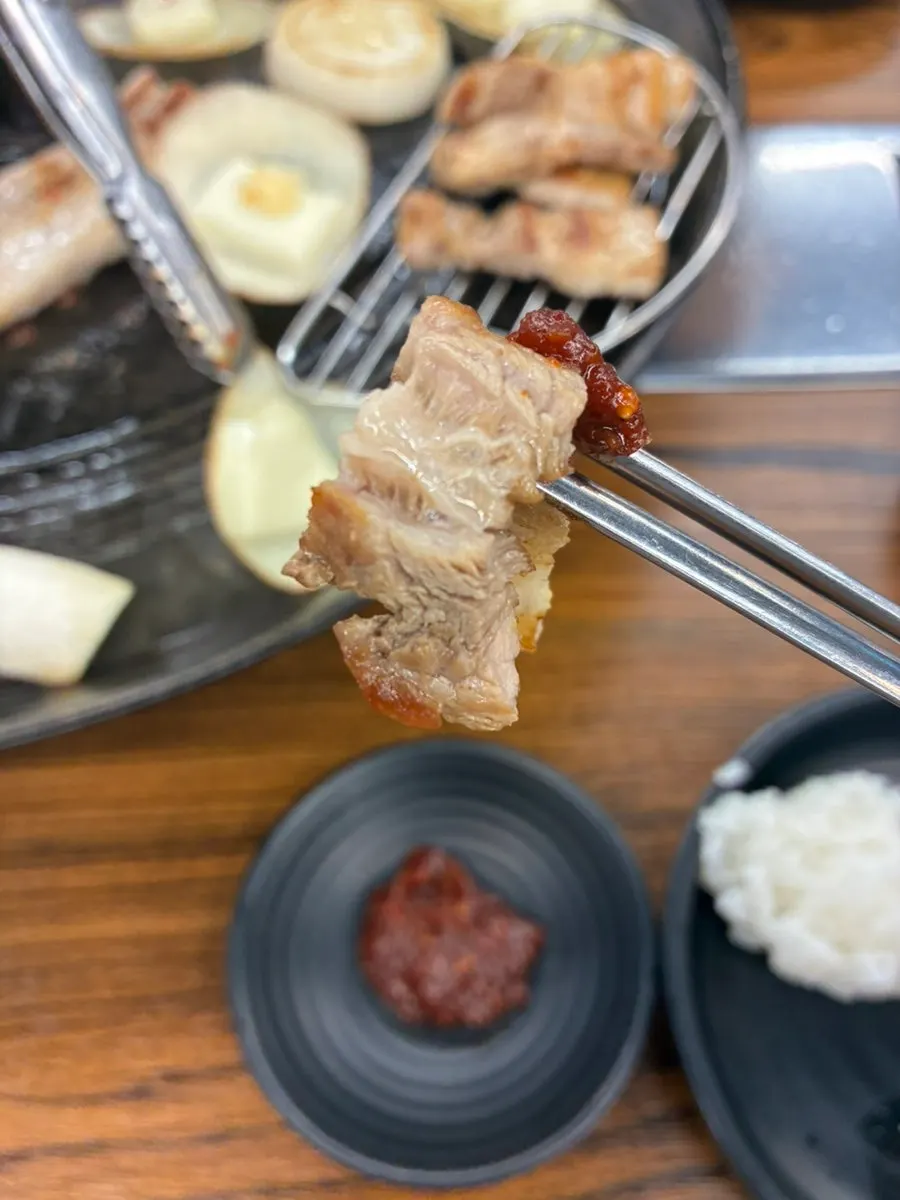 A piece of grilled pork belly with aged kimchi