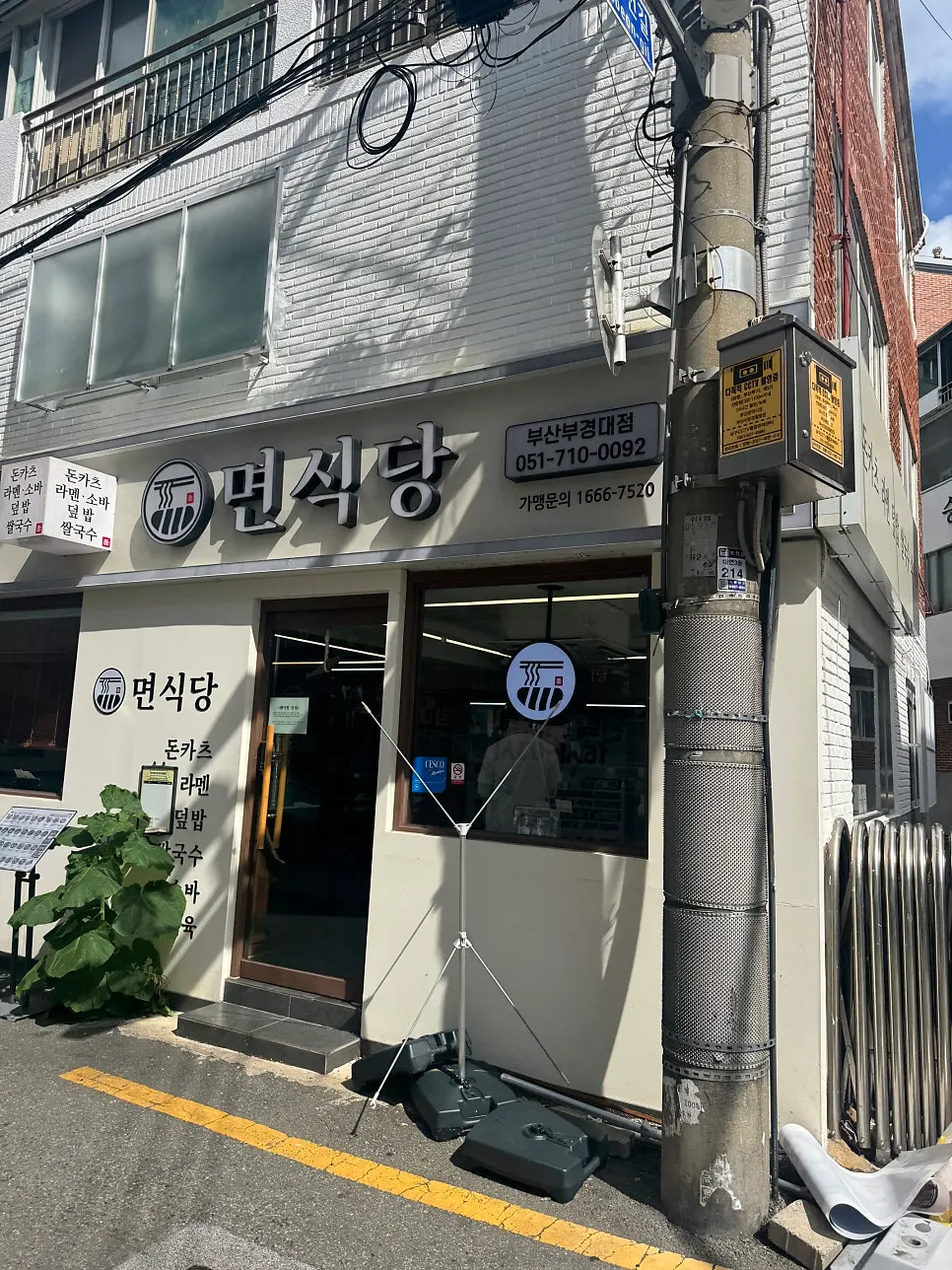 면식당 부경대점 외관과 문 앞 초록 식물