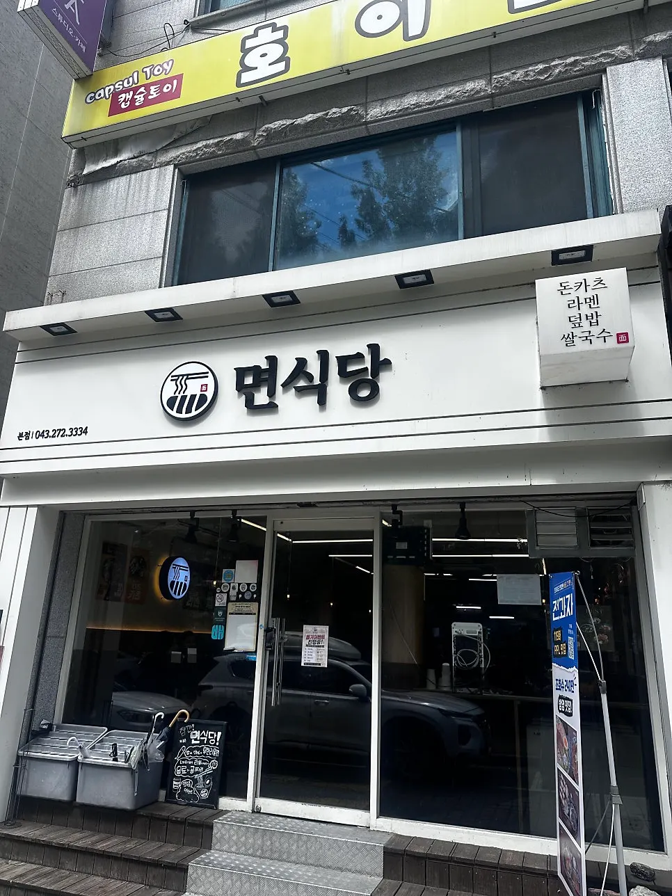 화이트 톤 간판과 통유리창의 면식당 충북대점 외관