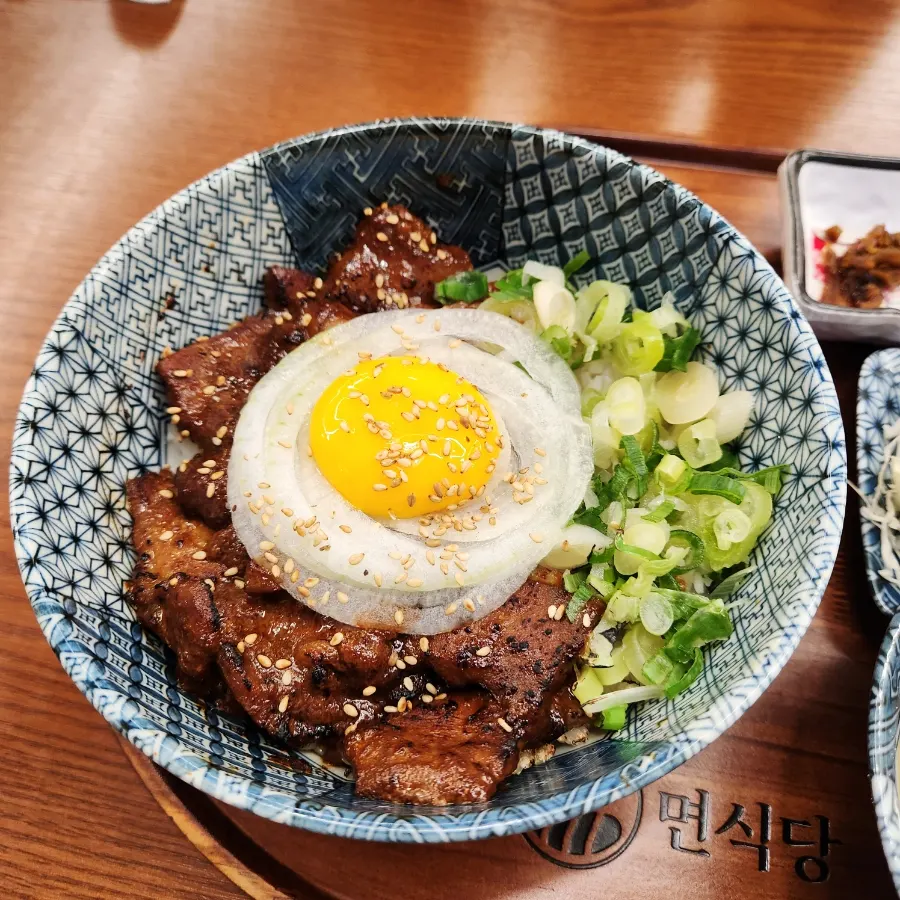 Spicy galbi rice bowl topped with egg yolk