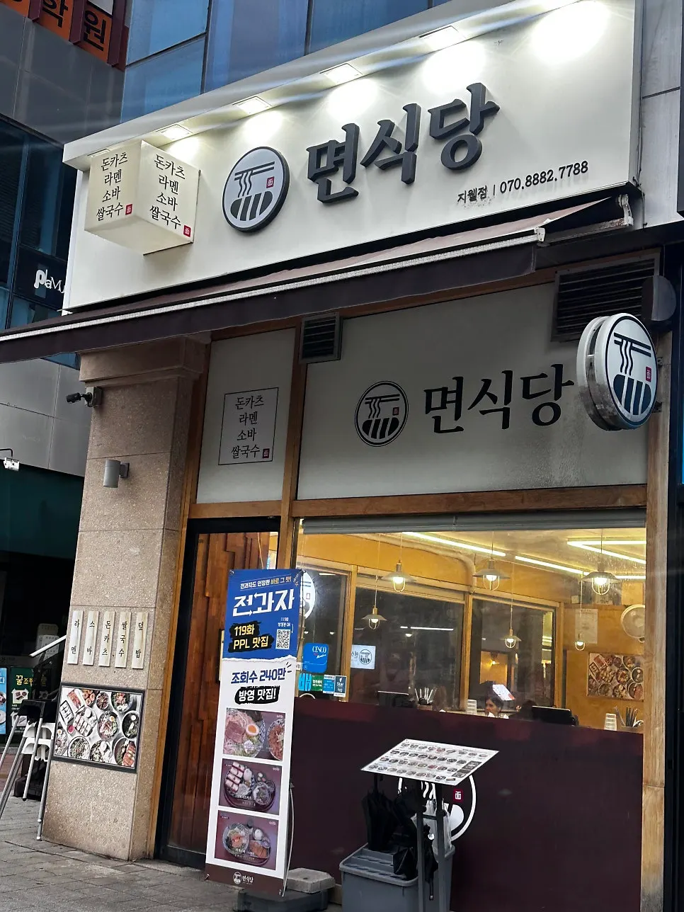 Exterior of Myeonsikdang Jiwel City with white sign and glass front