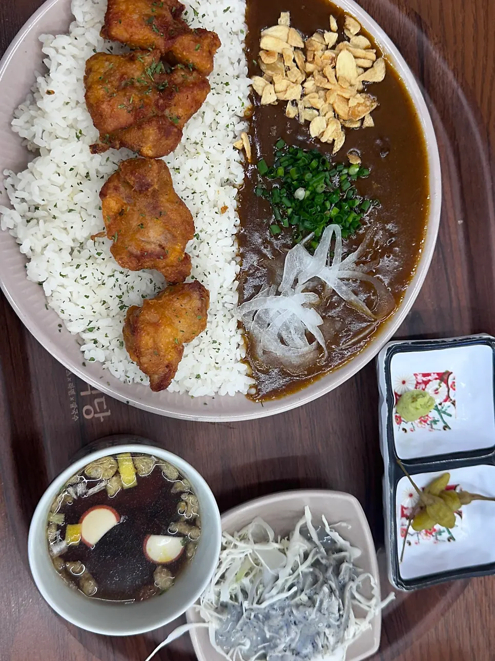 Karaage curry rice bowl mixed with garlic flakes and scallion garnish
