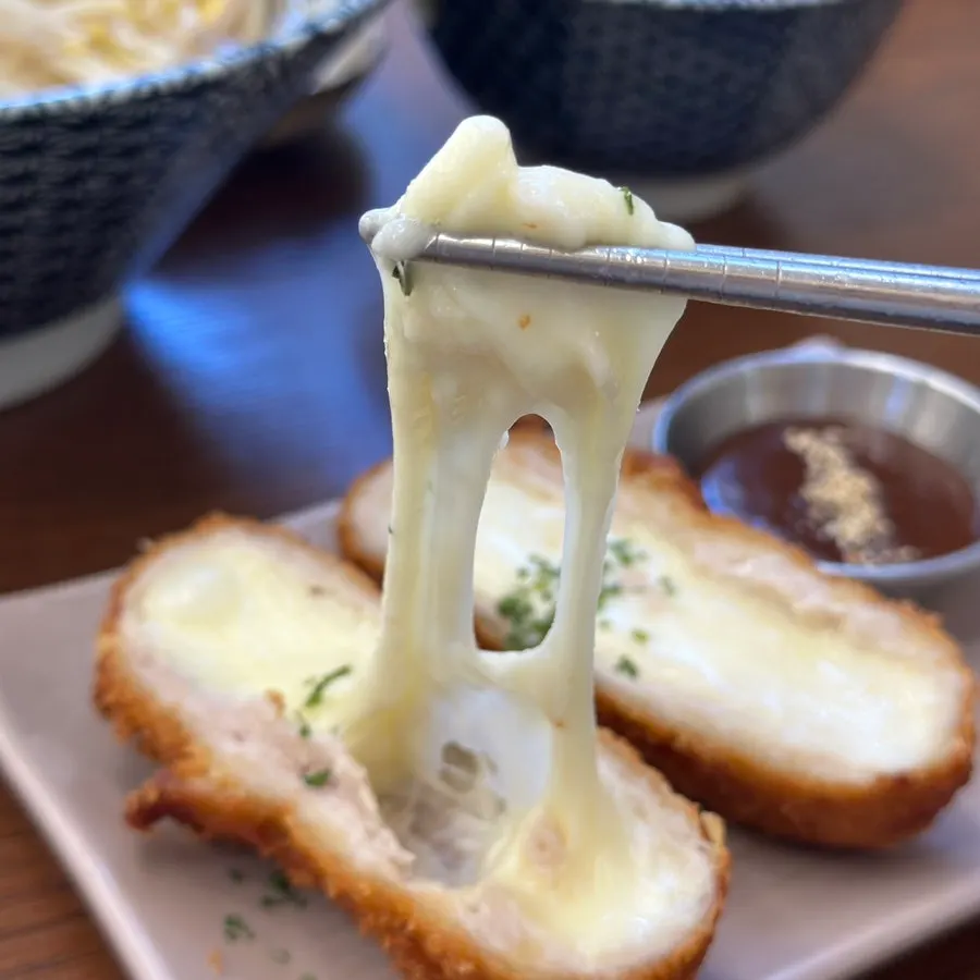 Cross-section of mozzarella cheese katsu with a cheese pull