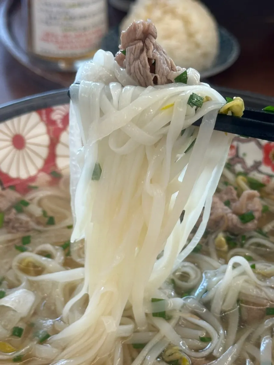 Shabu pho topped with red chili garnish