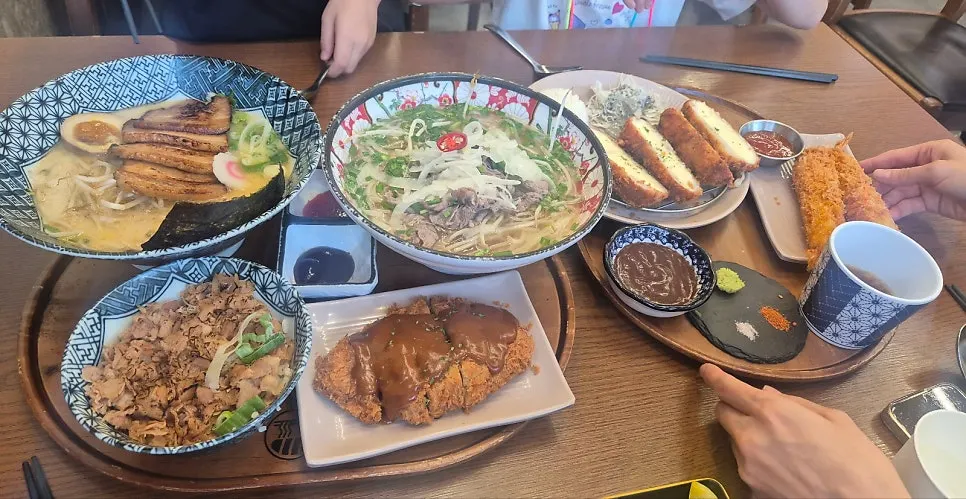 쌀국수와 라멘, 치즈카츠가 함께 놓인 테이블