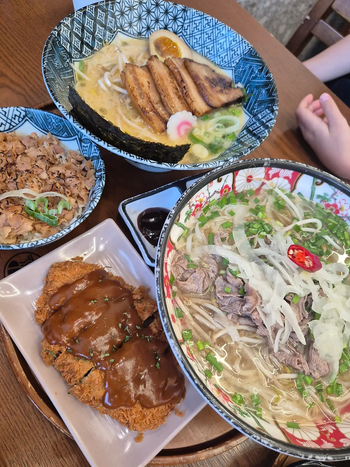 라멘과 쌀국수, 돈카츠가 차려진 가족 외식 상차림