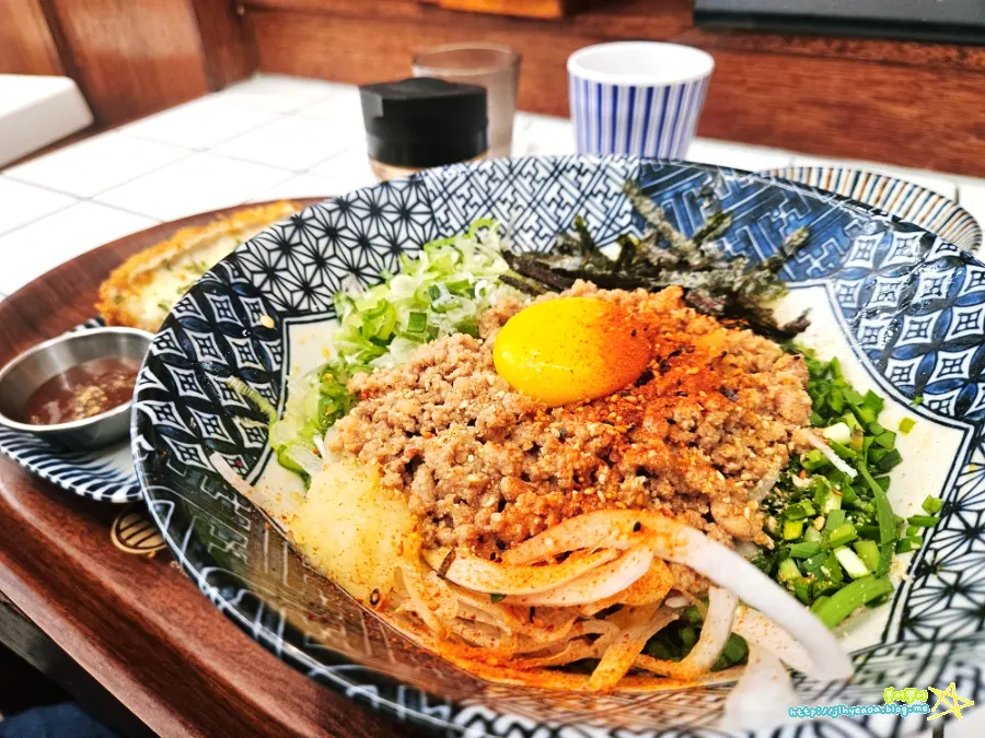 A bowl of mazesoba piled with toppings
