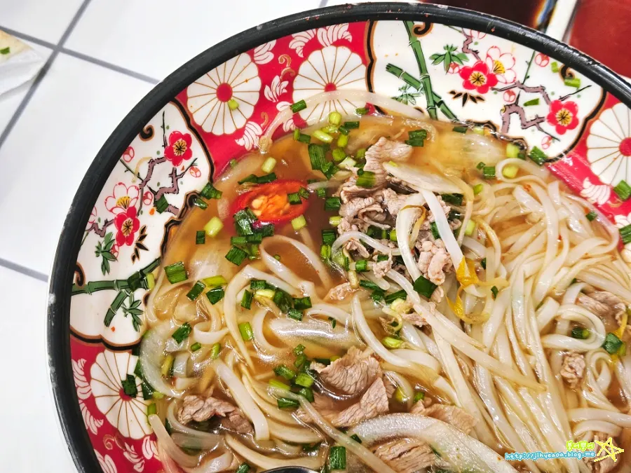 A bowl of spicy shabu rice noodle soup with a generous amount of noodles