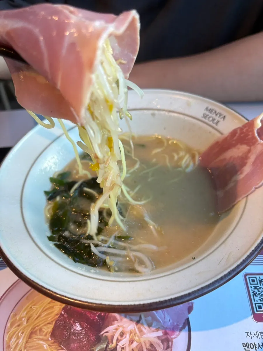 Ramen broth and noodles with bean sprouts and scallions