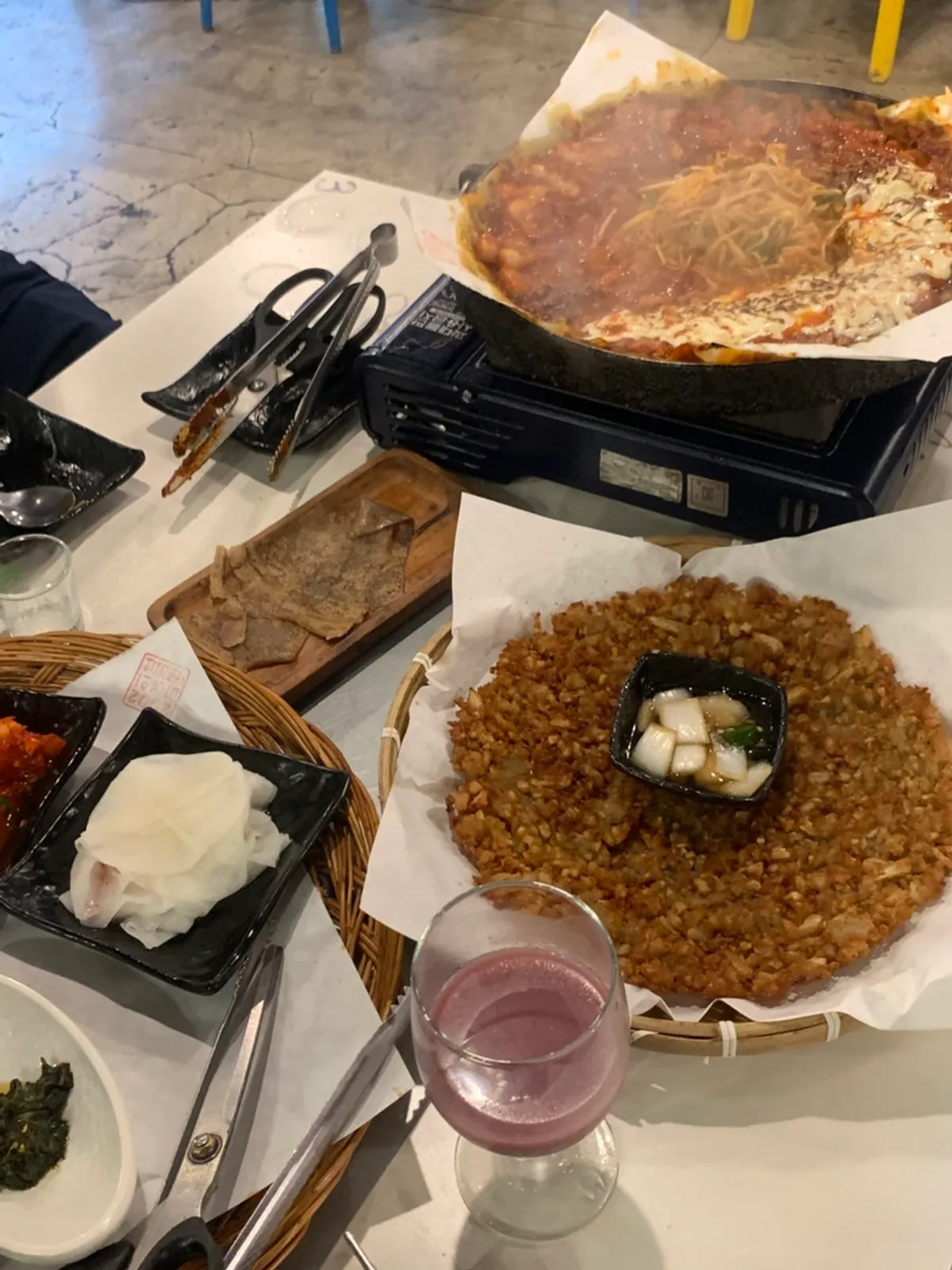 Table spread with tomato-jang pork belly and potato pancake