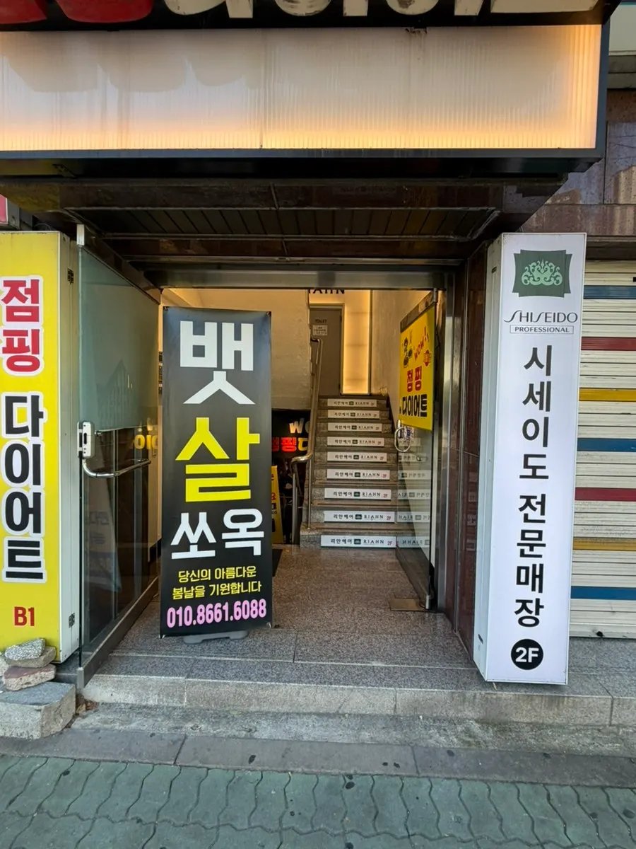 Street view of the salon building across from the Emart Everyday strip