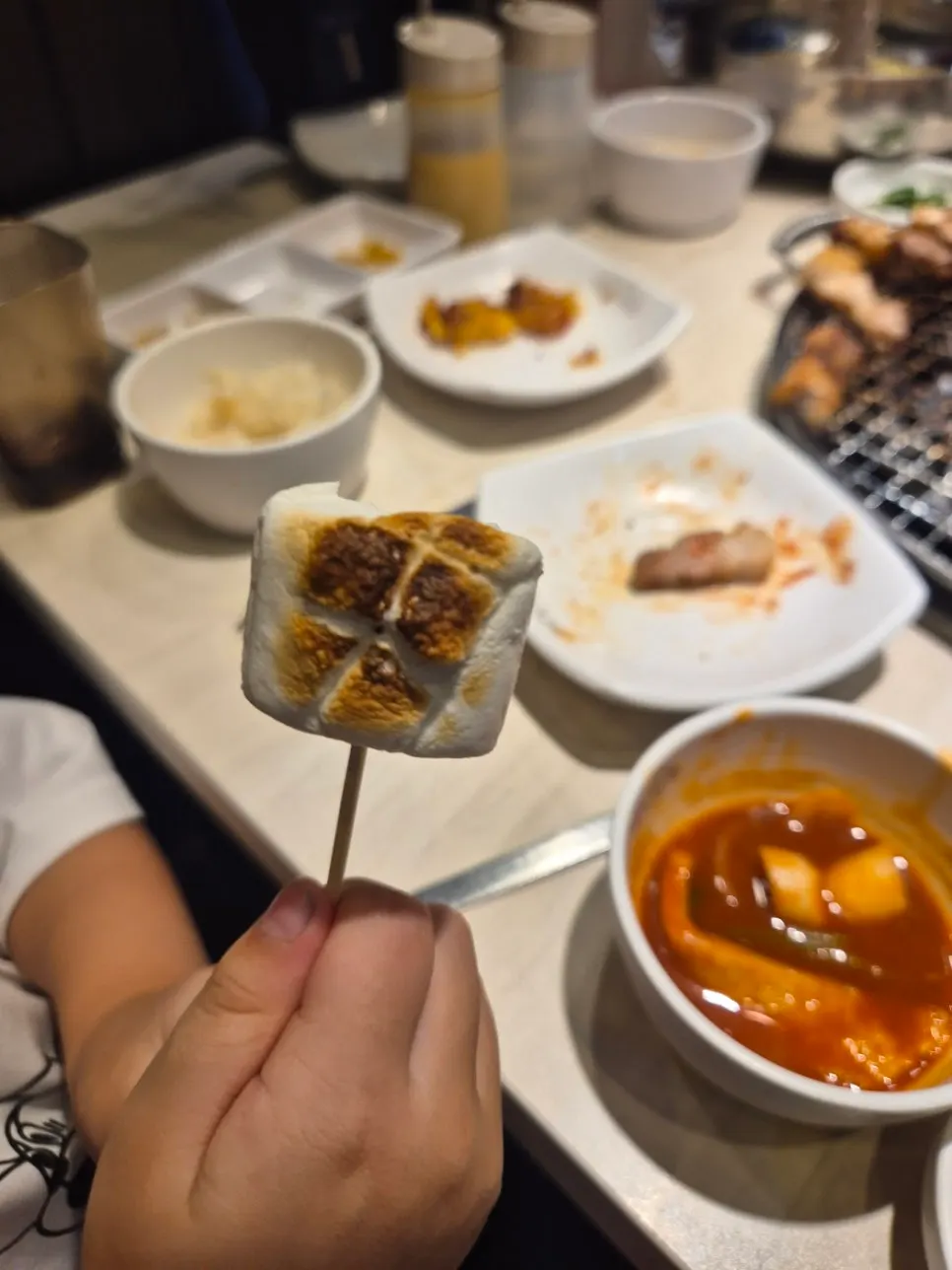 Dipping meat into cheese for galbi fondue