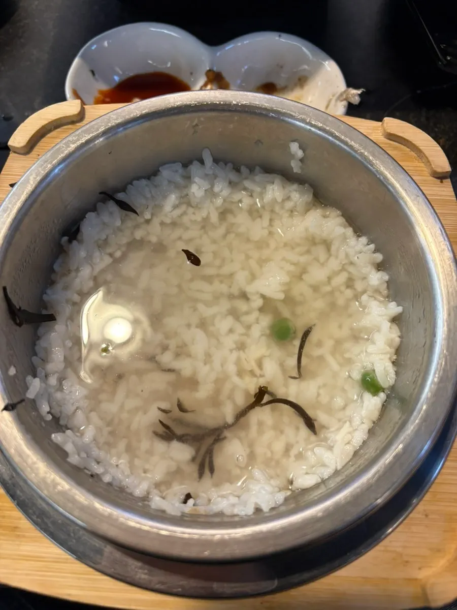 A bowl of hot pot rice with abalone served out