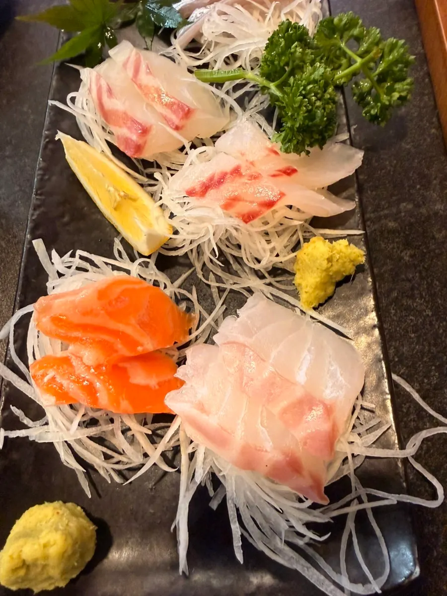 A piece of aged sashimi picked up with chopsticks