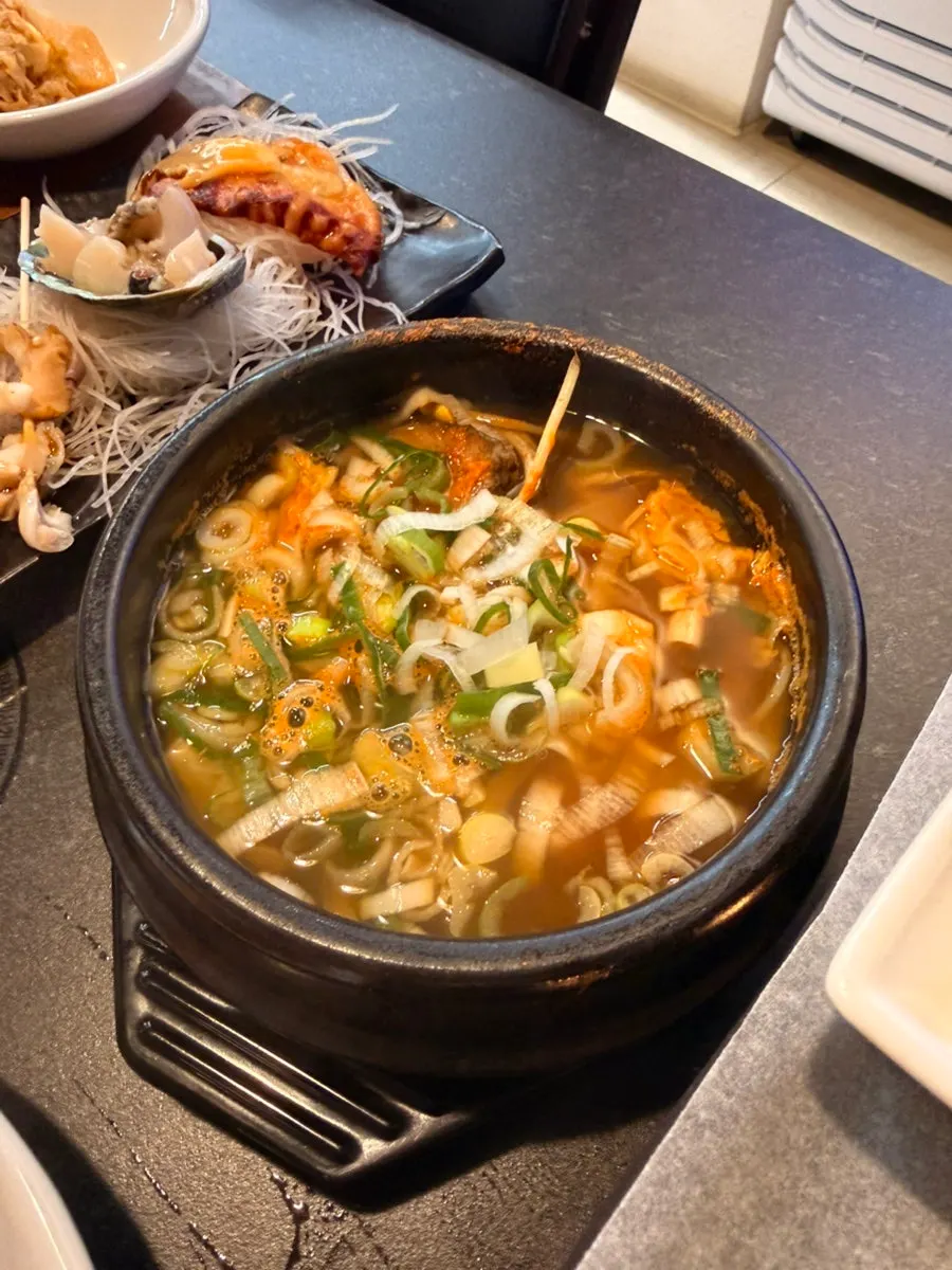 Side dishes at Naegohyang Jeju including cucumber salad and white kimchi