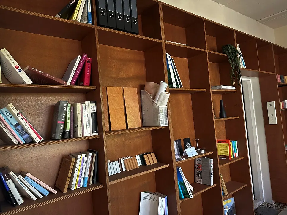 Bookshelf stacked with books and design magazines in the Flow space