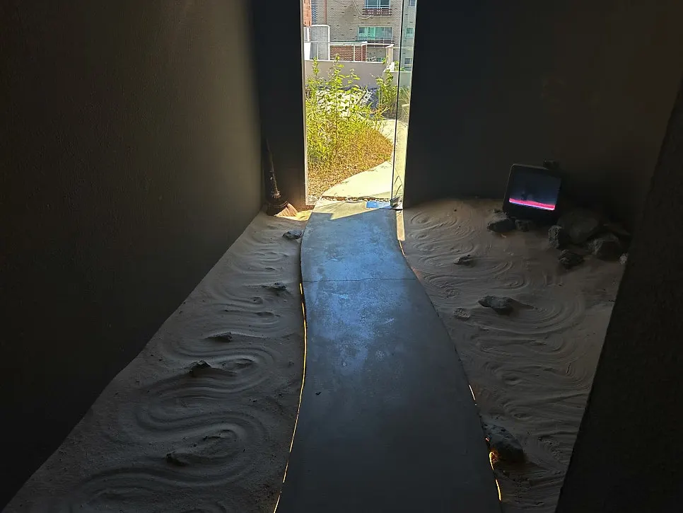 Dark sand-floored corridor leading up to the rooftop
