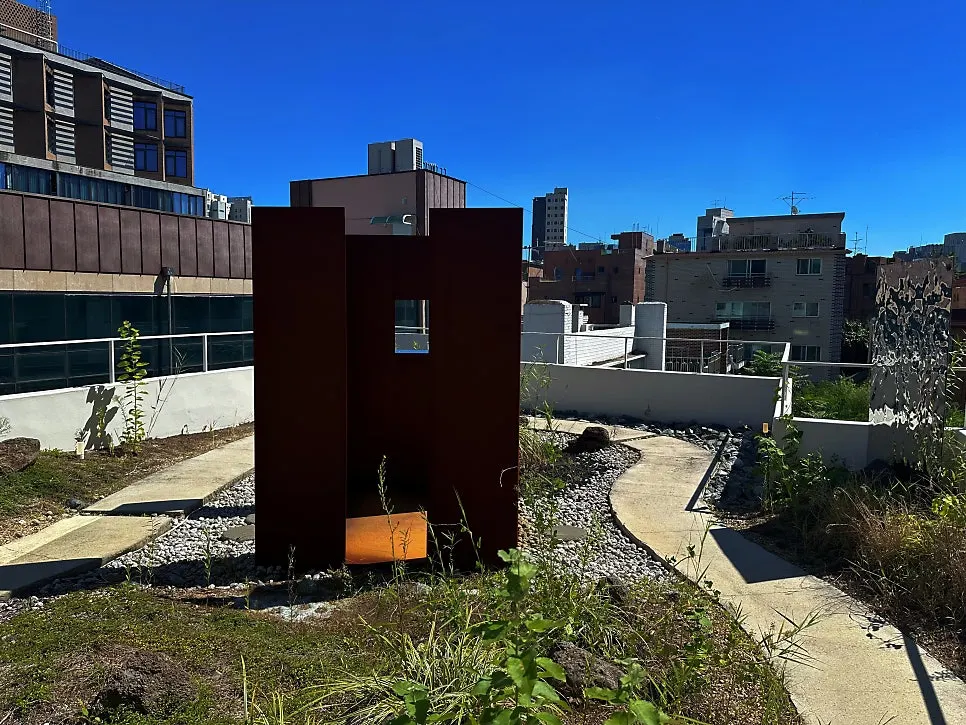 Large rusted steel structure in the middle of the rooftop garden