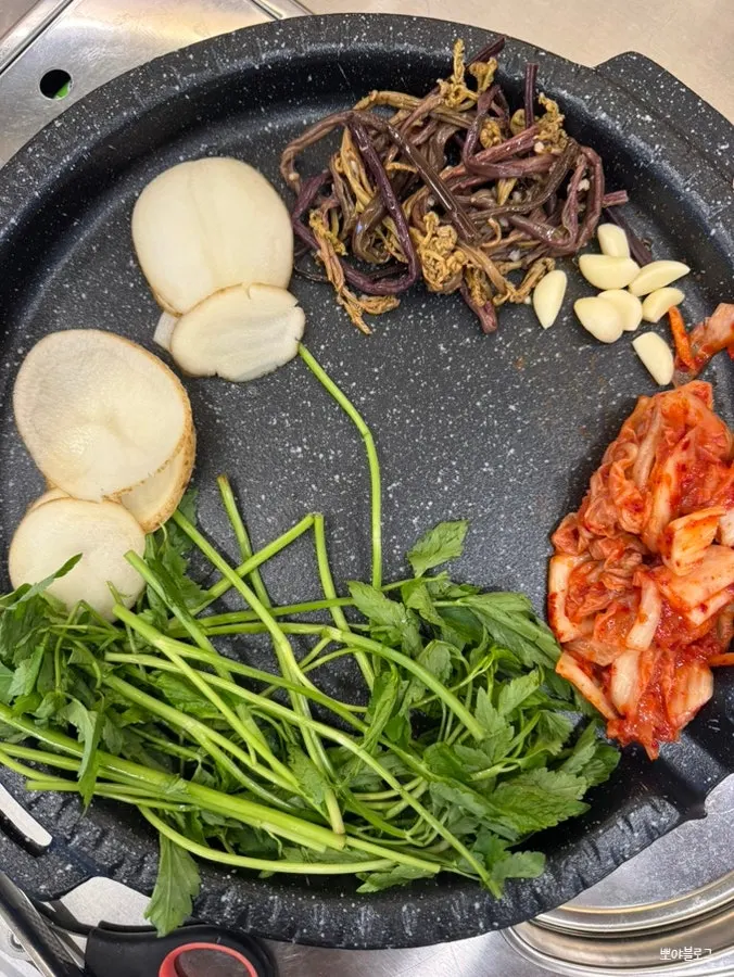 Grill loaded with minari, bracken fern, and kimchi