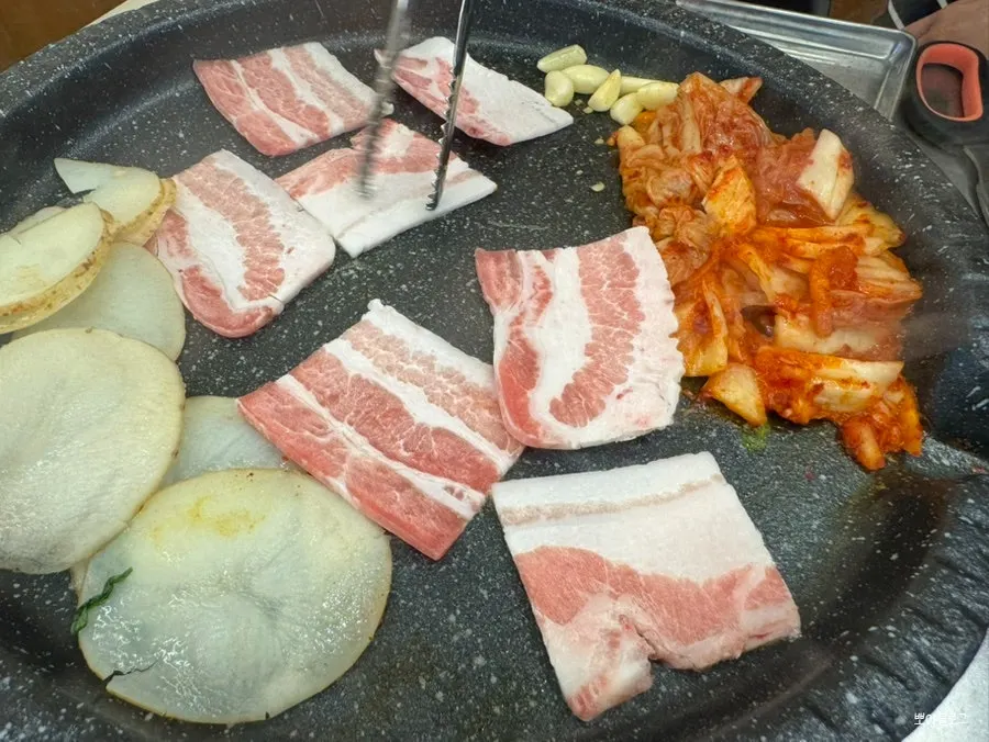Frozen pork belly cooking on the grill