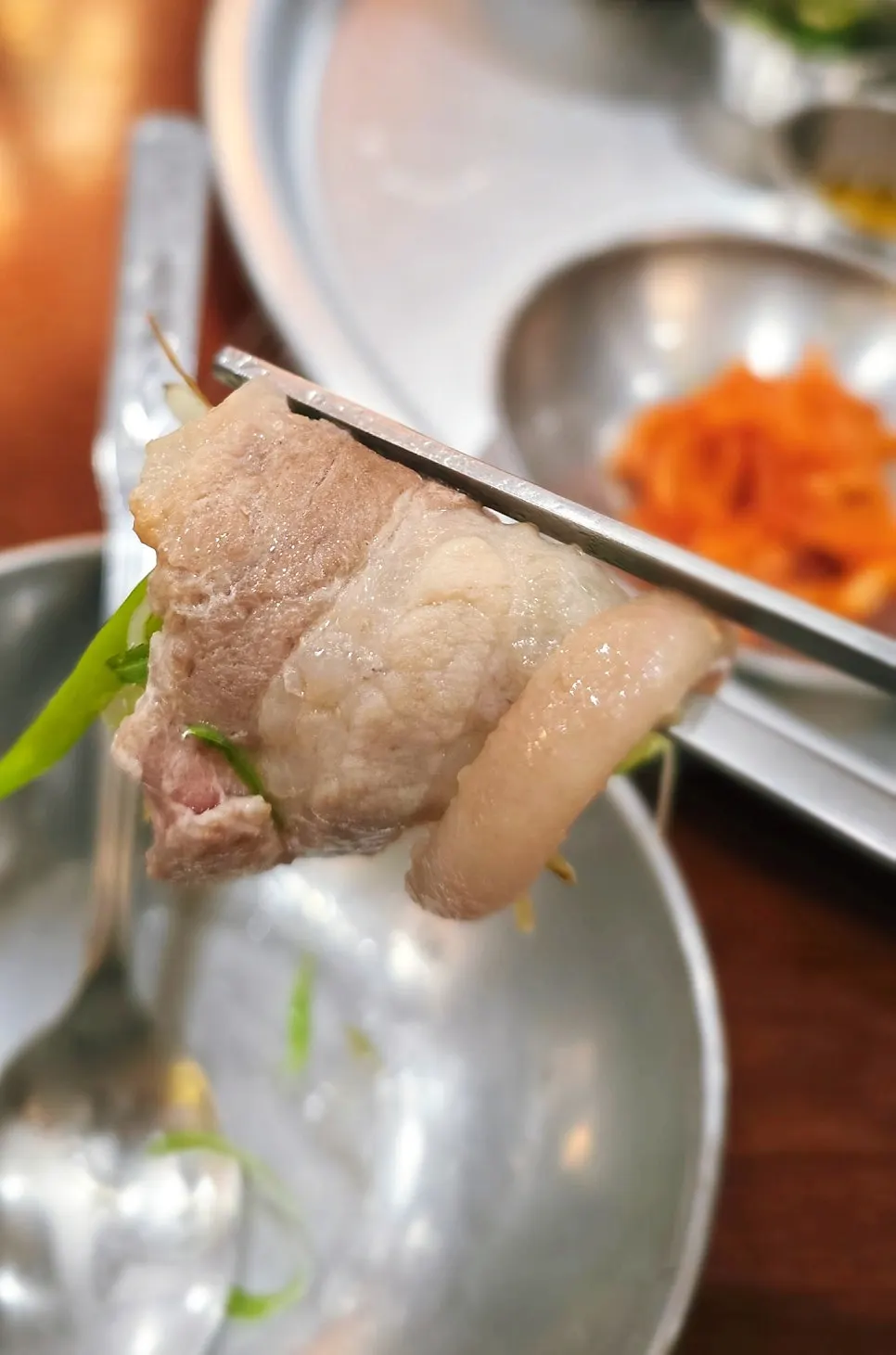 Green onion strips coated in egg wash grilling with frozen pork belly