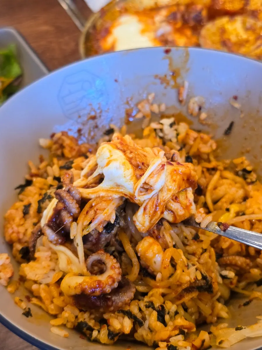 Rice and side dishes mixed with spicy octopus into bibimbap