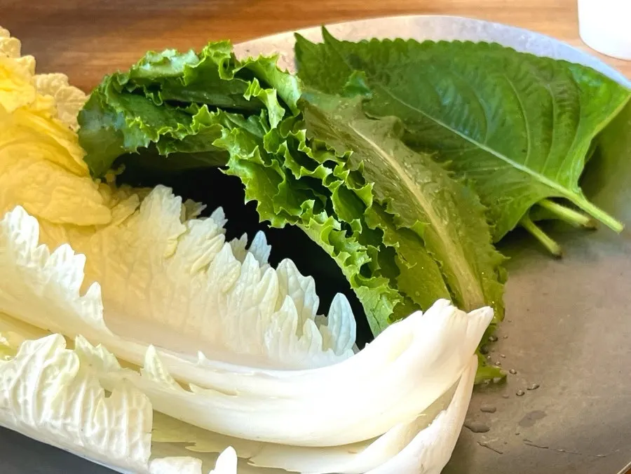 Bossam served with myeongtaehoe and wrap vegetables