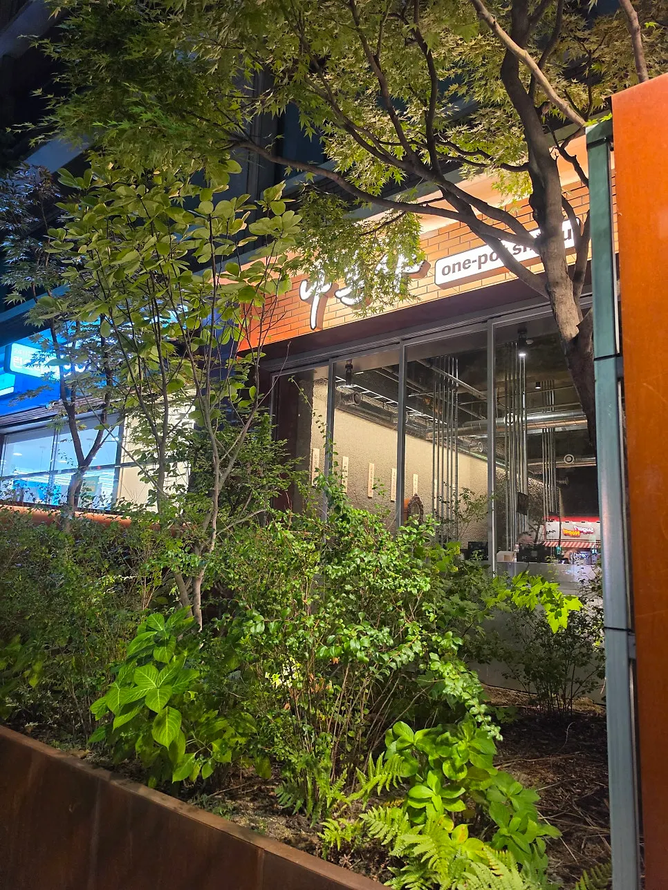 Nahonsha's exterior surrounded by green plants in the evening