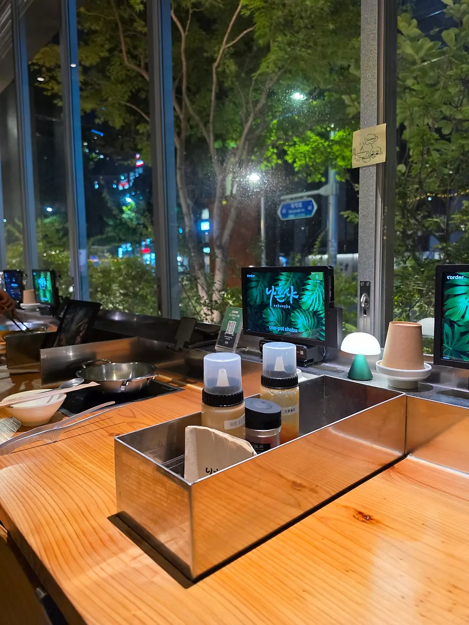Personal ordering monitor showing the Nahonsha logo with green trees outside the window