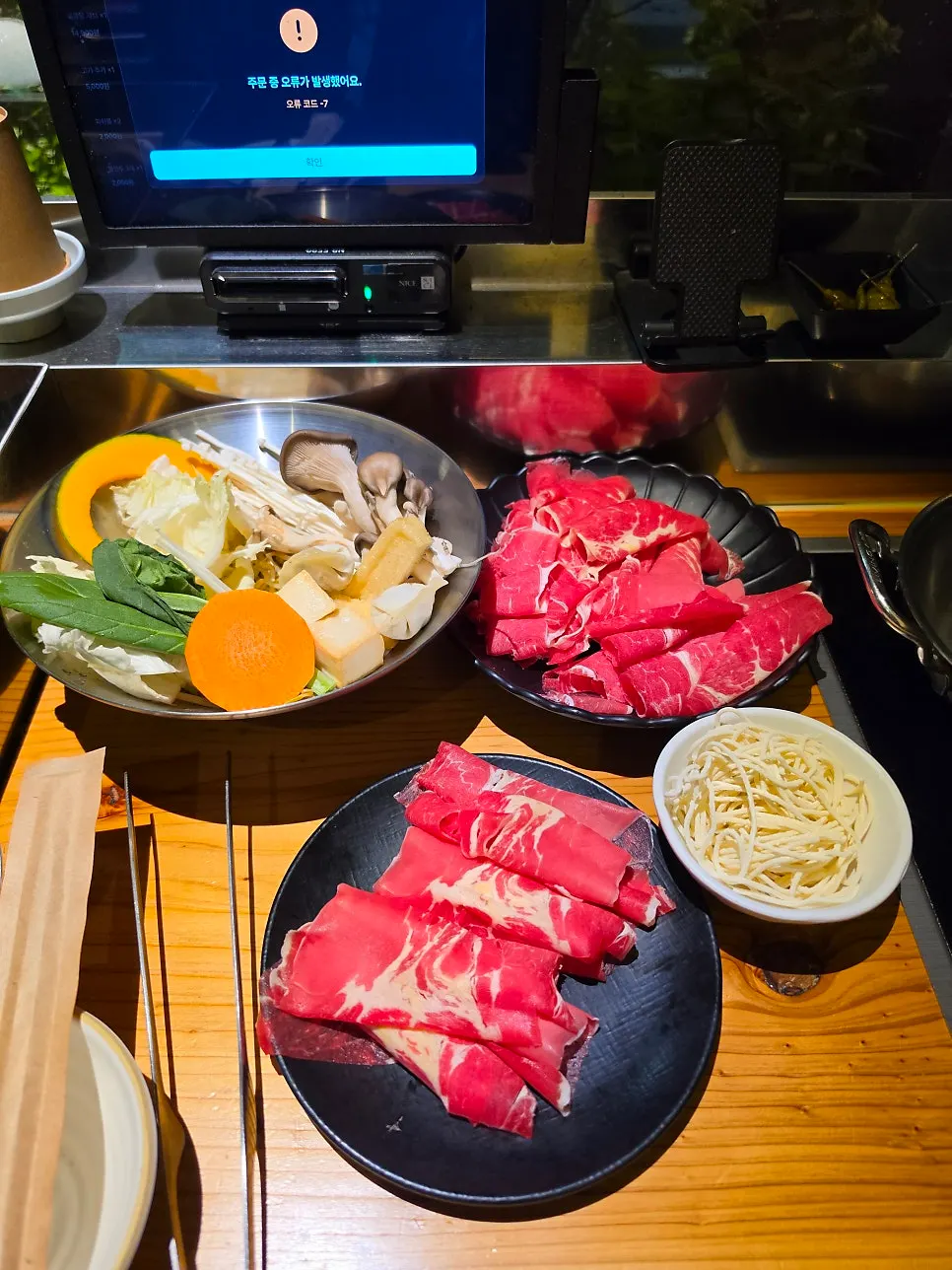 Basic spread of assorted vegetables, two plates of meat, and noodles