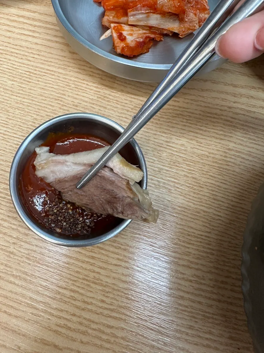 젓가락으로 집어든 뽈살 수육