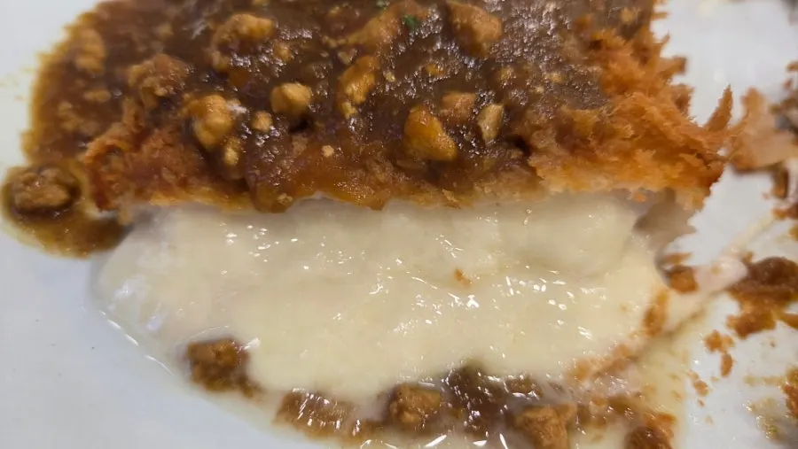 Pork cutlet topped with curry sauce and cheese